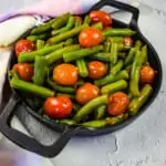 green beans & tomatoes in a black serving dish