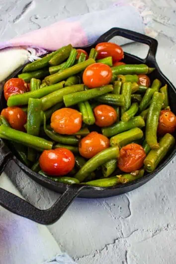 green beans & tomatoes in a black serving dish