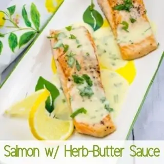 salmon with herb butter sauce on a platter.