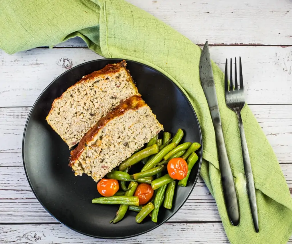 keto turkey meatloaf with bacon on a plate with beans