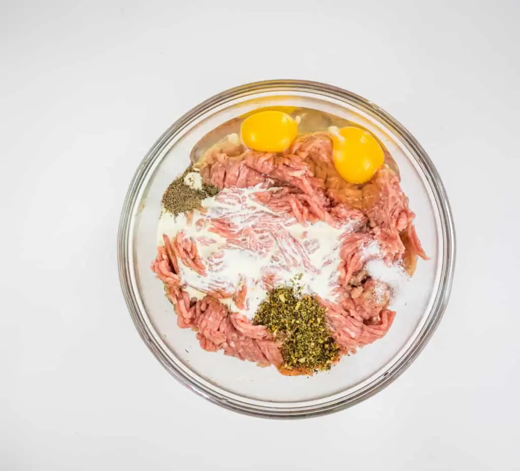 adding ingredients to the ground turkey