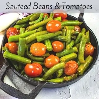 sauteed green beans & tomatoes in a black dish