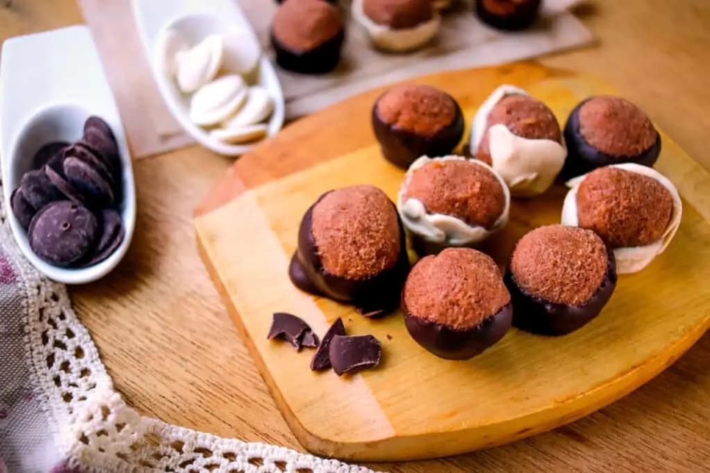 Chocolate peanut butter balls on a wood board.