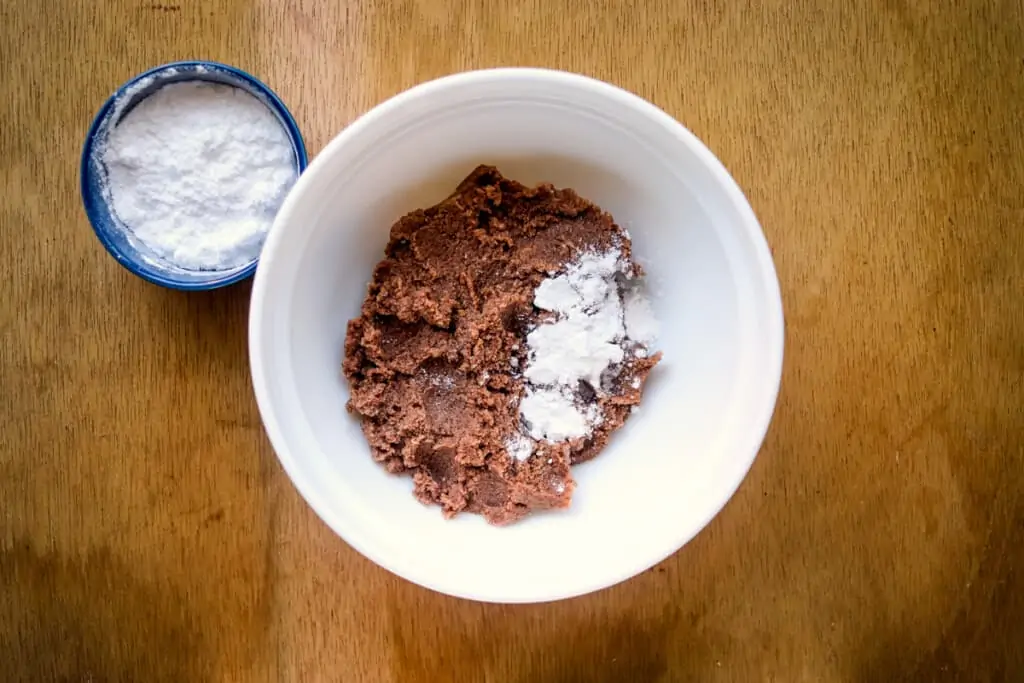 Mixing sugar and peanut butter in a bowl.