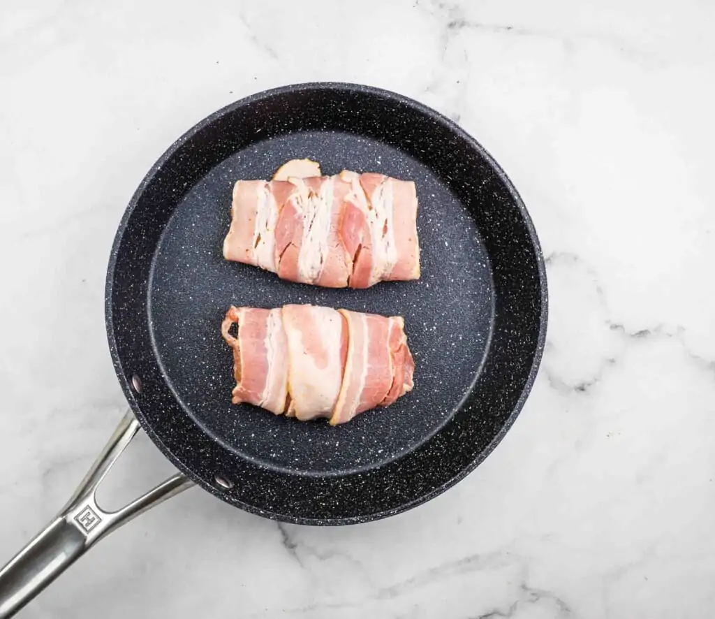 bacon wrapped cod filets in a skillet