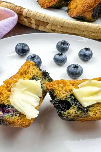 Sliced Keto Blueberry Muffins on a plate with butter