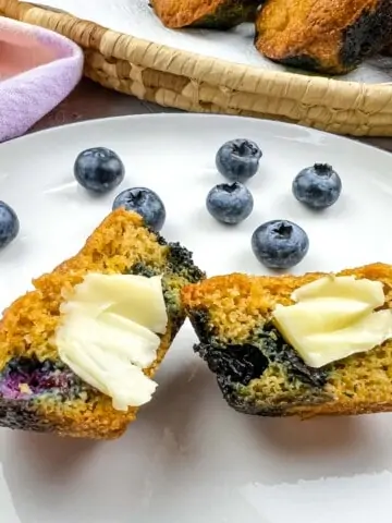 sliced keto blueberry muffins on a plate with butter
