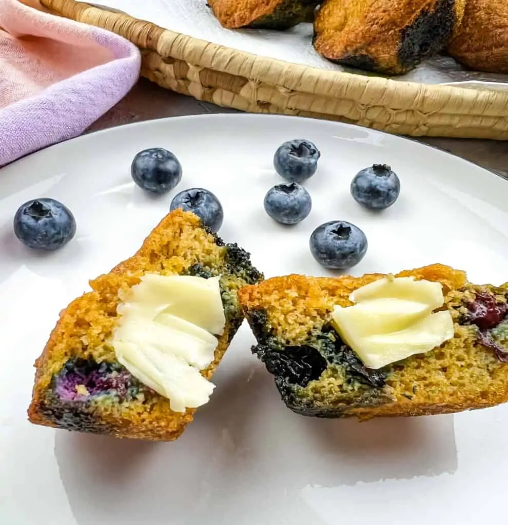 sliced keto blueberry muffins on a plate with butter