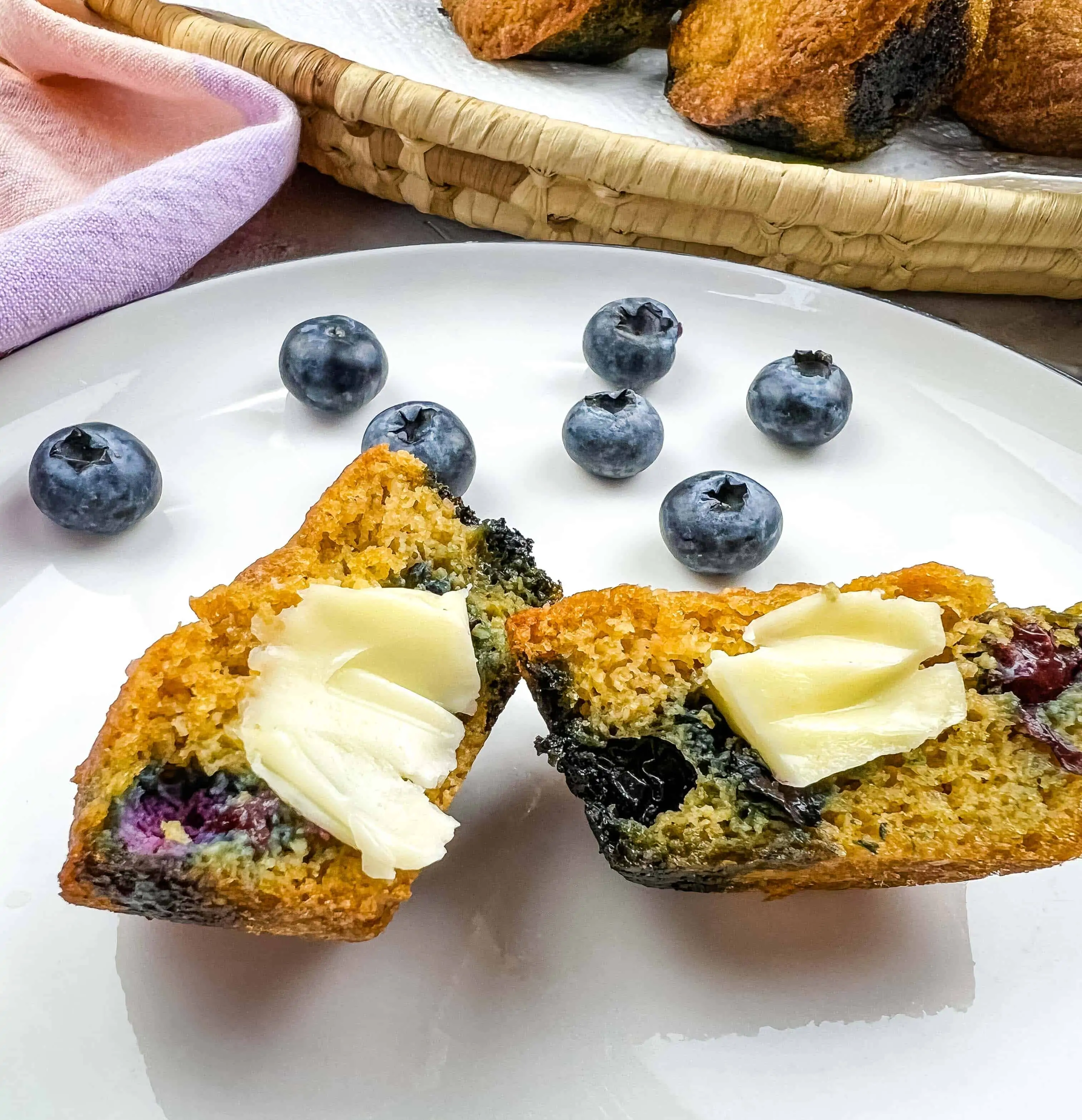 Sliced Keto Blueberry Muffins on a plate with butter