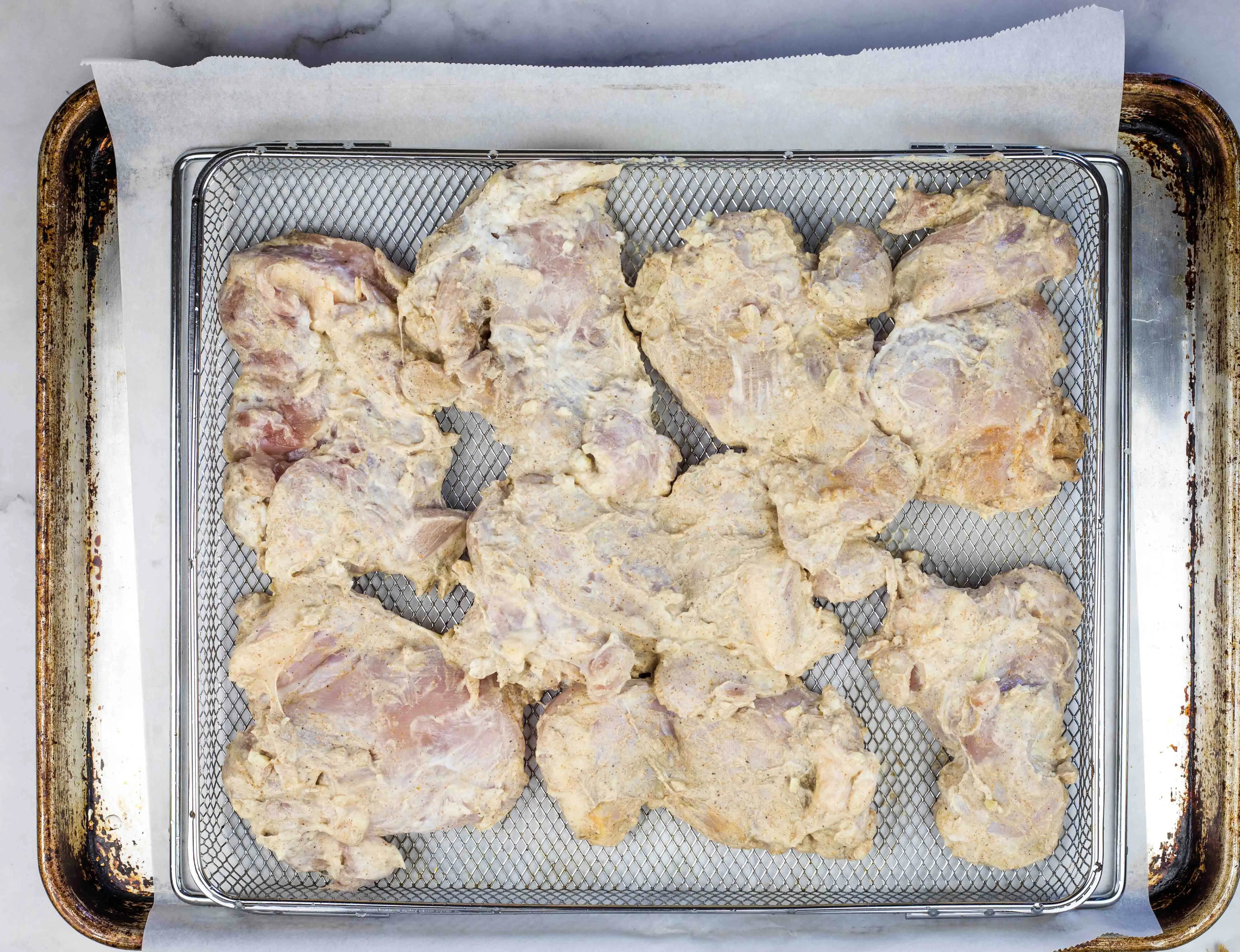 chicken on a baking sheet ready to be broiled