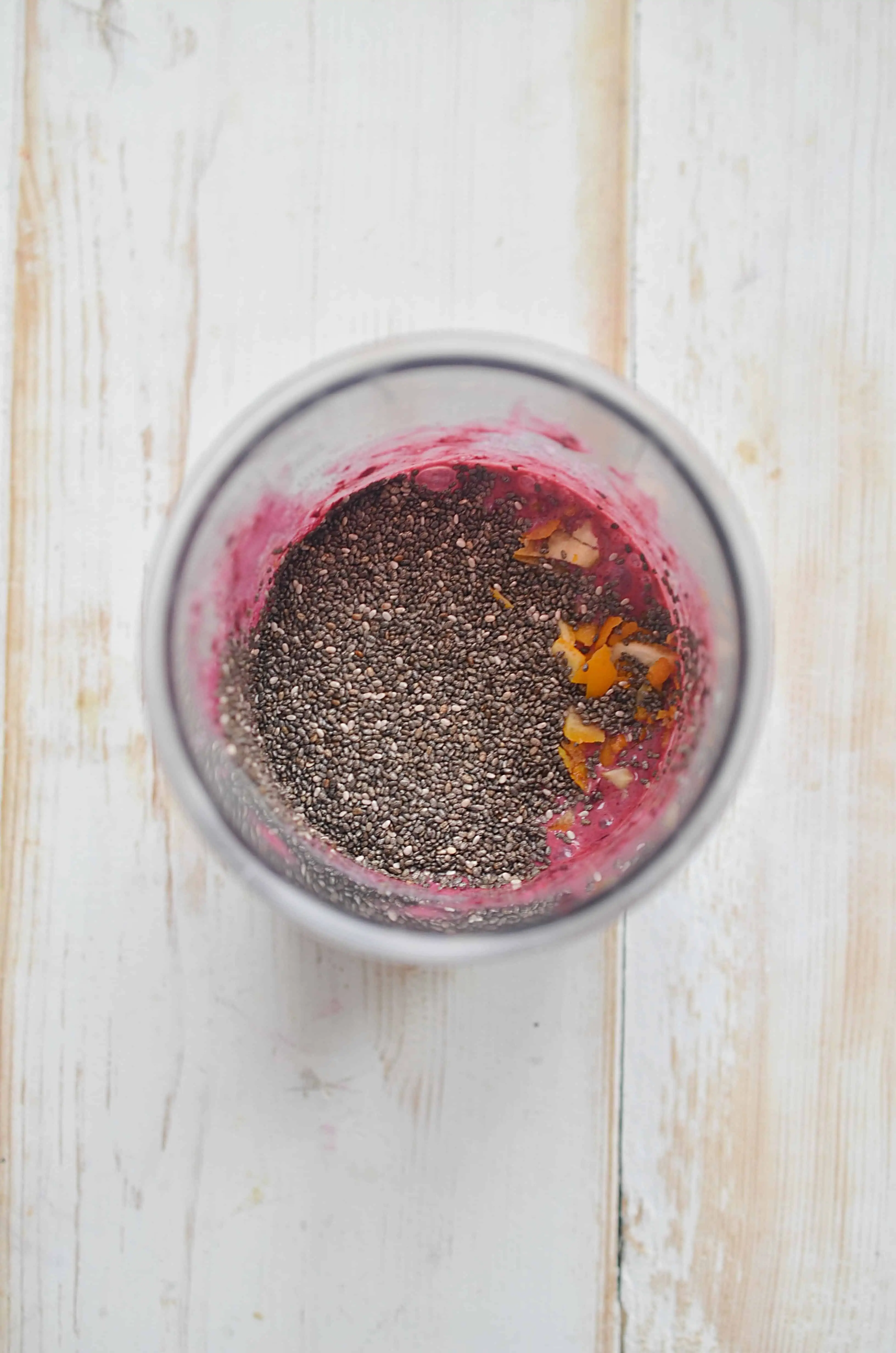 A jar with the dry chia seeds and pureed blueberries-almond milk.