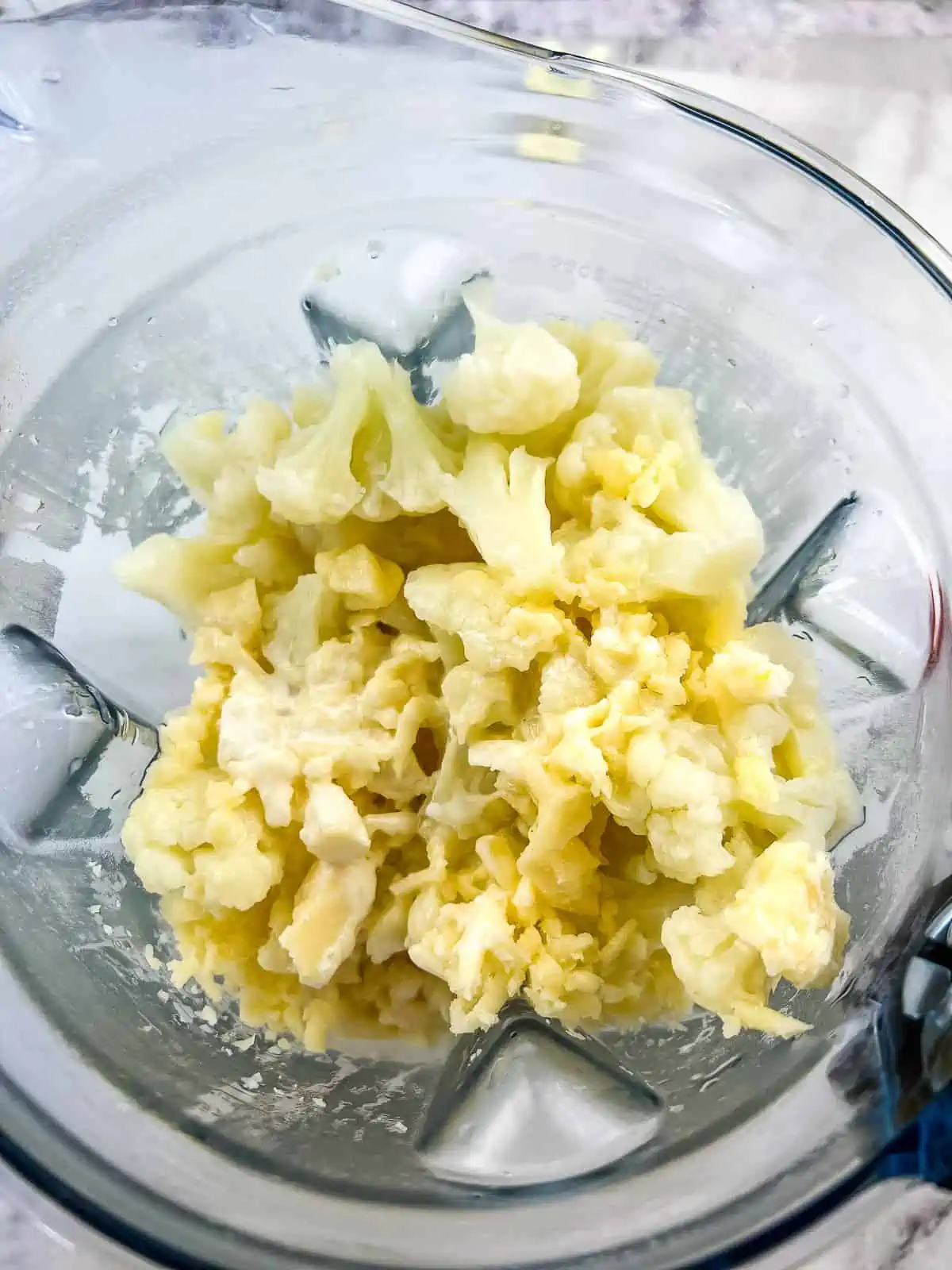 Cooked cauliflower, cheese, egg, and cream in a blender.