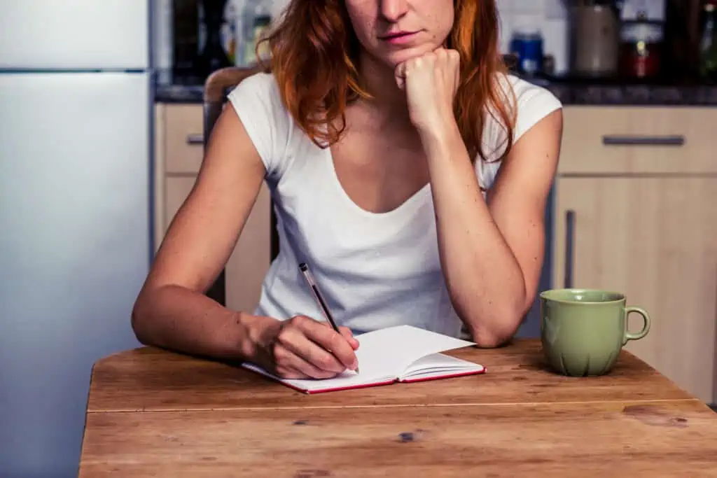 woman at a table making a shopping list