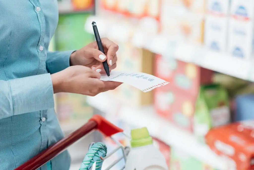 woman at the grocery store with a shopping list in hand