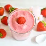 keto strawberry smoothie in a glass with strawberries nearby