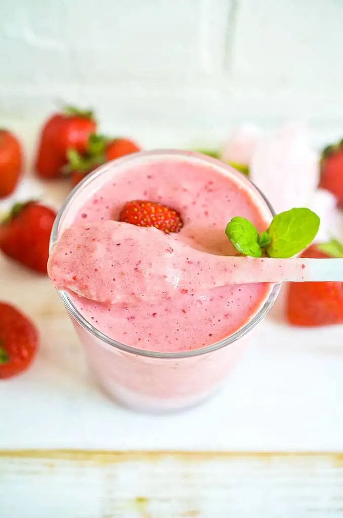 a keto strawberry smoothie with a spoon in the glass