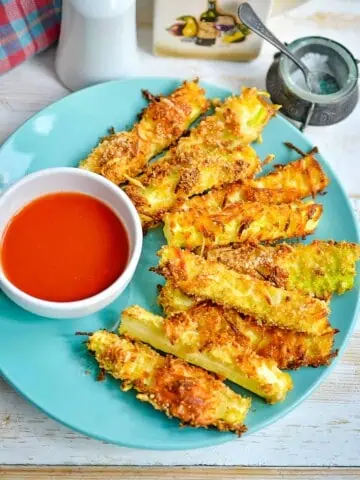 keto zucchini fries on a plate with sauce in a bowl