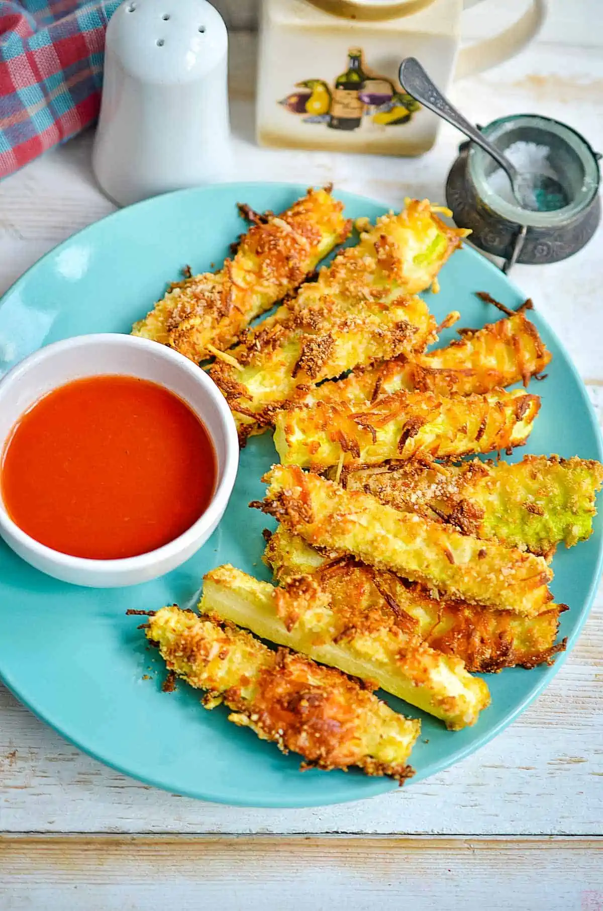 keto zucchini fries on a plate with sauce in a bowl