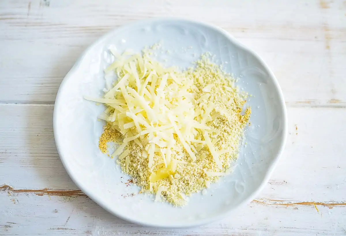 Cheese, almond flour, and spices mixed on a plate.