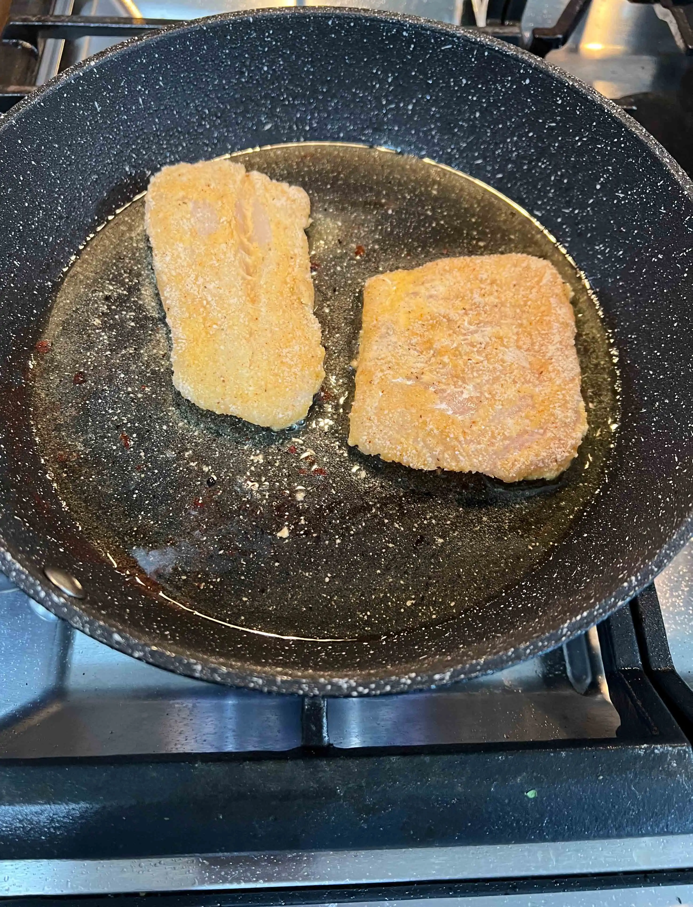 Shallow frying the cod in oil in a skillet.