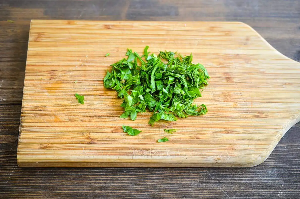 Finely chopped parsley on a cutting board.