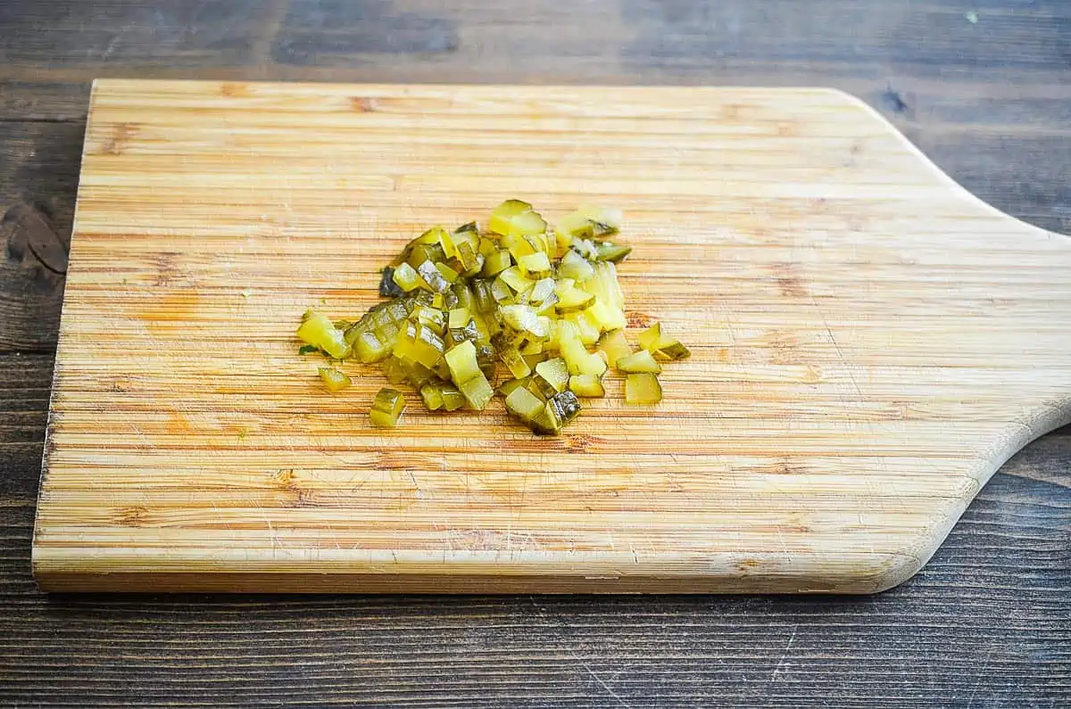 Finely chopped pickle on a cutting board.