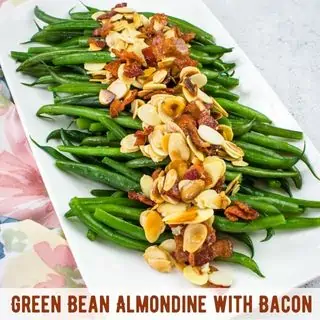 Green bean almondine with bacon on a white platter.