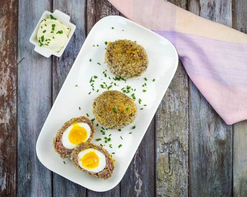 a top-down shot of keto scotch eggs on a white platter.