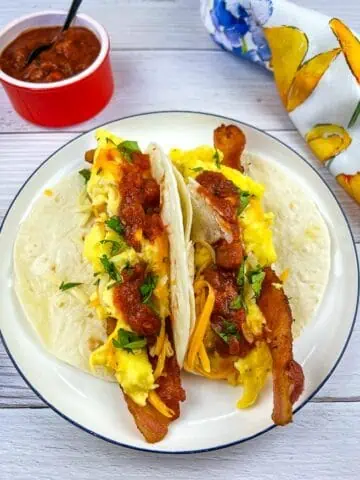 Low-Carb Breakfast Tacos on a plate with salsa nearby.