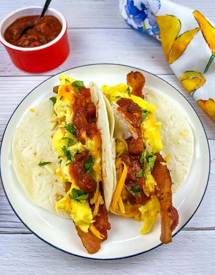 Low-Carb Breakfast Tacos on a plate with salsa nearby.