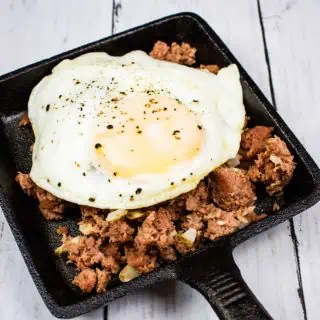 Keto Corned Beef Hash served in a black dish with an egg on top.
