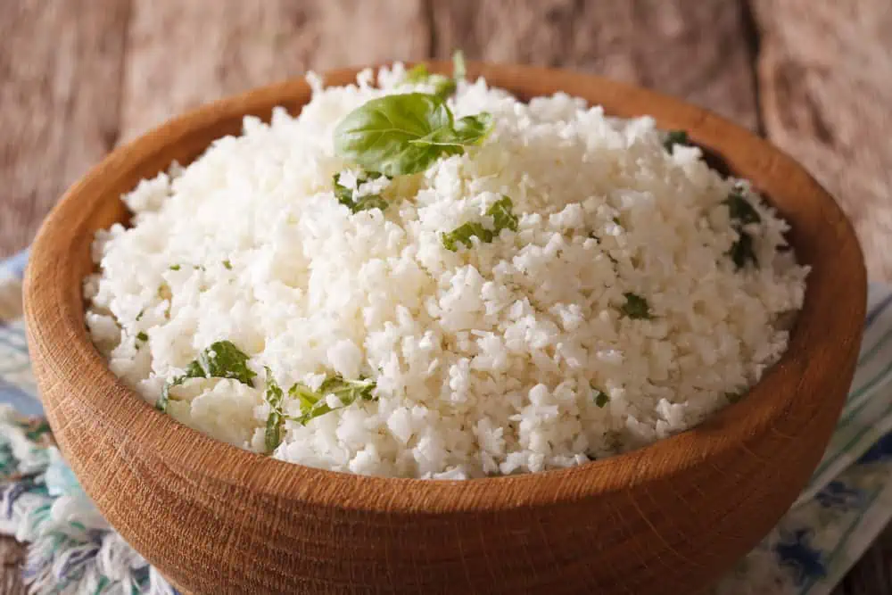 A close-up photo of cauliflower rice with herbs.