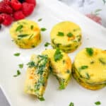 Egg Bites with Spinach & Cheese on a serving plate with berries on the side.