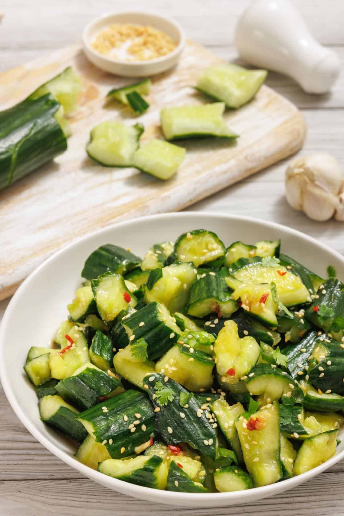 A bowl of cucumbers with sesame seeds and sesame oil.