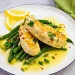A round plate filled with chicken scampi below the roasted green beans,