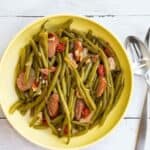A plate of Southern Style Green Beans beside a spoon and fork.